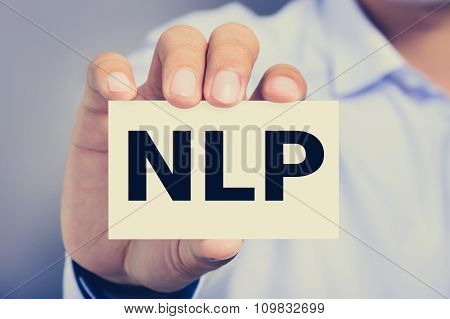 Nlp Letters (or Neuro Linguistic Programming)  On The Card Shown By A Man