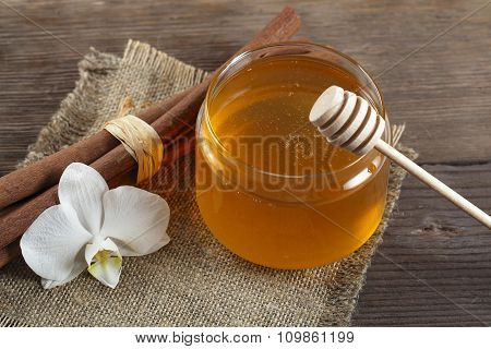 Heather honey and cinnamon on wooden table.
