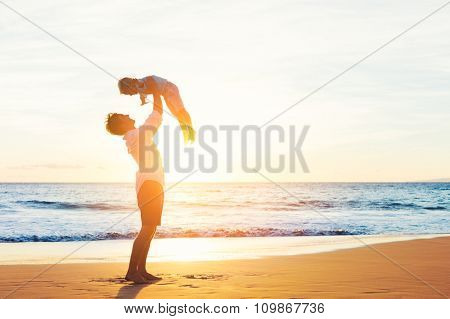 Happy Joyful Father and Son Having Fun Playing on the Beach at Sunset. Fatherhood Family Concept