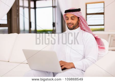 modern young arabian man using laptop computer at home