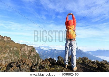 young woman hiker hiking on mountain peak