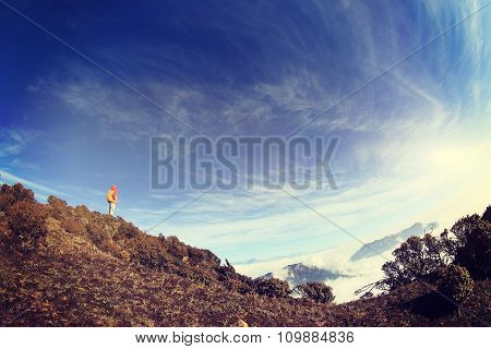 young woman hiker hiking on mountain peak