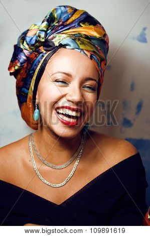 beauty bright african american woman with creative make up, shawl on head like cubian closeup