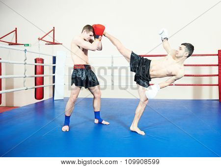 Thai kickboxing. Muay thai sportsman fighting at training boxing ring