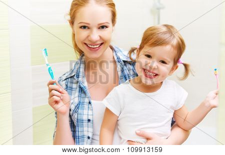 Happy Family Mother And Daughter Child Brushing Her Teeth Toothbrushes