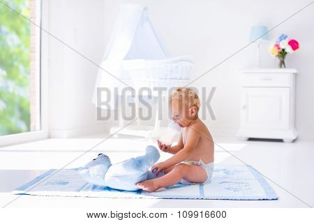 Baby Boy With Milk Bottle In Sunny Nursery