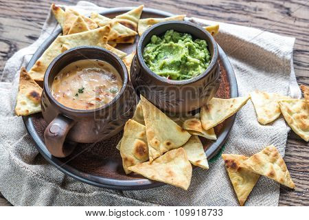 Bowls Of Guacamole And Queso With Tortilla Chips
