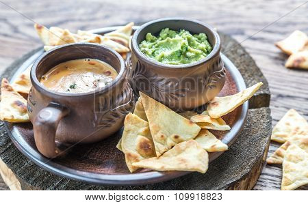 Bowls Of Guacamole And Queso With Tortilla Chips