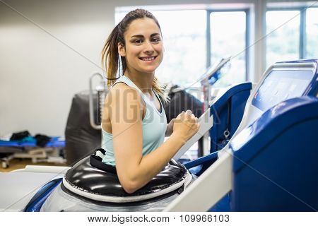Smiling woman using an anti gravity treadmill at the gym