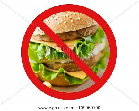 fast food, low carb diet, fattening and unhealthy eating concept - close up of hamburger or cheeseburger behind no symbol or circle-backslash prohibition sign