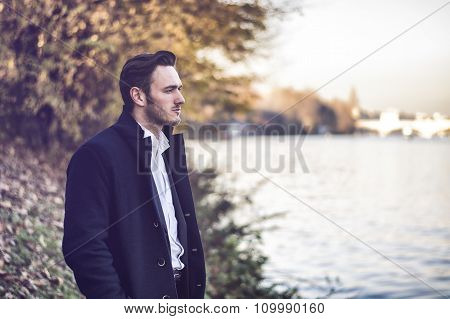 Young man outdoor in winter by lake or river