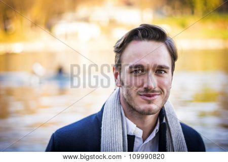 Young man outdoor in winter by lake or river