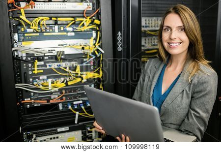 Technician using laptop to analyse server at the data centre