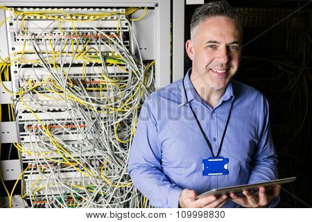 Technician using tablet pc while analysing server at the data centre