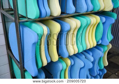 Colorful Foam Kickboards On Silver Metal Rack By Swimming Pool