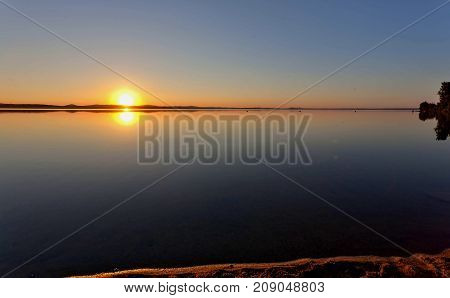 Golden Sun Sinks Over The Lake In The Evening