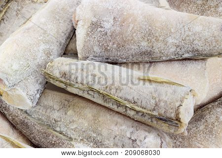 Background of carcasses of the frozen saltwater fish notothenia without of a heads and tails covered with rime