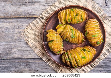 Freshly baked hasselback potatoes with parsley .