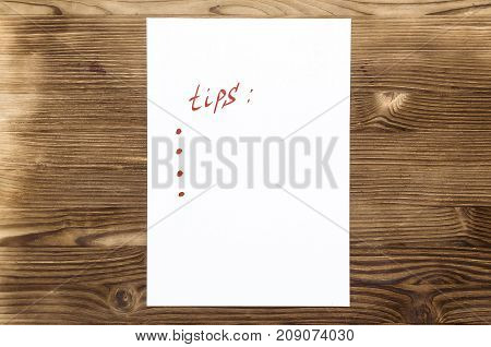 Tips note paper page with copy space on wooden desk table surface background.