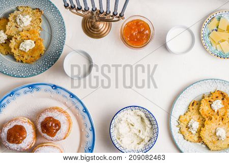 Plates with latkes, donuts, curd cheese for a festive feast horizontal