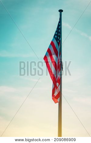USA flag on pole in sunset american national banner with stars and stripes in the evening