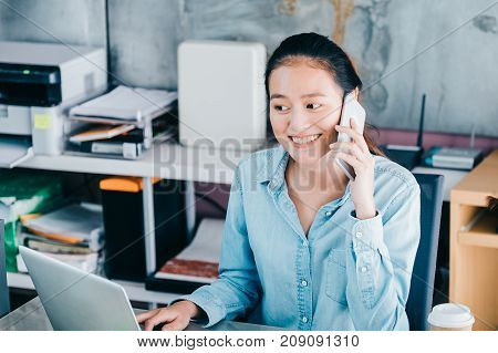 Asian creative designer contact customer at mobile pone with smiling facestart up owner company concept.
