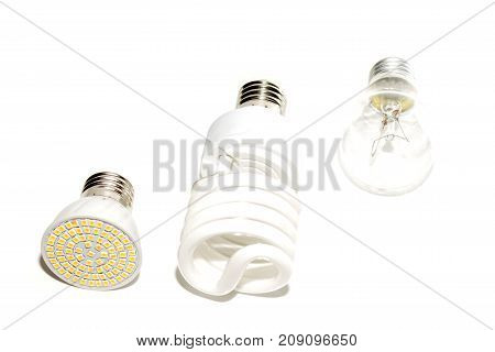 Several different led bulbs and compact fluorescent lamps with the size of the male screw base E27 on a light background