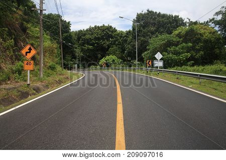 curve uphill road and yellow street zigzag sign with 40 miles speed limit. Success milestone concept to reach upper goal