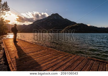 Hiker Looking Sunset Over The Lake.