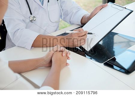 Patient Listening Intently To A Male Doctor Explaining Patient Symptoms Or Asking A Question As They