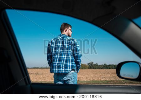 man stands on a road view from the car window