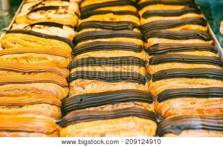 Savory coffee and chocolate eclair desserts in a French pattiserie vitrine glass display case
