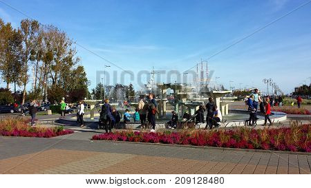 Gdynia, Poland - October 15, 2017: Fountain on the Kosciuszko Square in Gdynia, Poland. People stand at the fountain in the 

center of Gdynia.