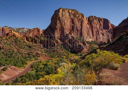 Amazing Autumn view of Kolob Canyon, part of Zion National Park in Utah, and red road meandering up to the lookout point.