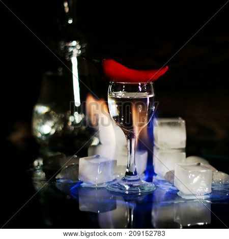 A Shot Of Vodka, An Alcoholic Beverage, Next To Ice, Fire, Ice, Red Chili Pepper. The Concept Of Alc