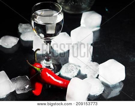 A Shot Of Vodka, An Alcoholic Beverage, Next To Ice, Fire, Ice, Red Chili Pepper. The Concept Of Alc