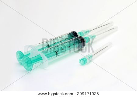 5 ml syringes ready for medical injection vaccination. Two medical syringes in the hospital laboratory. Plastic medicine vaccination equipment in clinic. One syringe without cap and needle