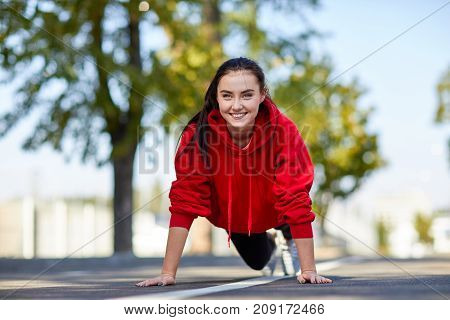 Lovely girl in red uniform girl squeezes off the floor in the street