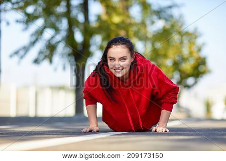 Lovely girl in red uniform girl squeezes off the floor in the street