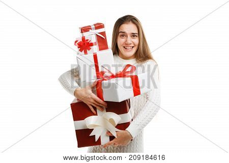 Beautiful smiling girl with a long hair posing on the camera in studio and holding christmas gift isolated on white background. Close-up of gifts. Holiday concept.