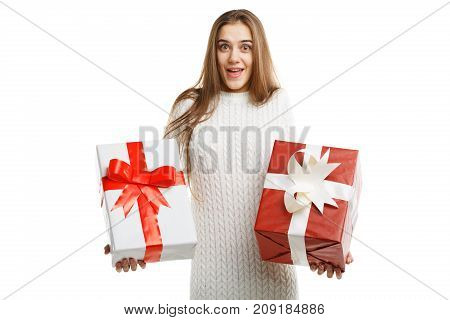 Pretty cutie girl with a long hair posing on the camera in studio and holding christmas gift isolated on white background. Close-up of gifts. Holiday concept.