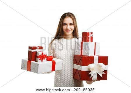 Pretty cutie girl with a long hair posing on the camera in studio and holding christmas gift isolated on white background. Close-up of gifts. Holiday concept.