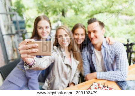 Friends who have fun in a cafe. Do selfie. Blurred background. Concept of leisure.
