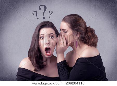 A teenager girl looking confused with drawn question marks above the head, while a girlfriend whispers something in her ear concept.