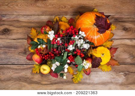Thanksgiving Centerpiece With Snowberry And Pumpkins On Wooden Background