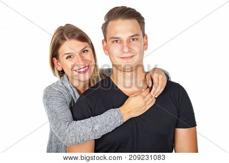 Joyful young couple embracing and smiling on isolated background