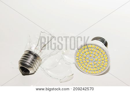Several different led bulbs and compact fluorescent lamps with the size of the male screw base E27 on a light background