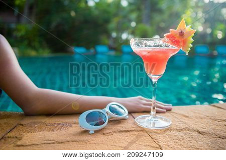 Women wearing bigini or swimware suits swimming pool Drinking water melon smoothie at the resort town of Pattaya in Thailand.