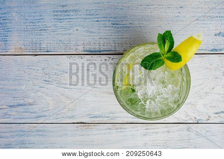 Alcohol mojito cocktil bar long drink fresh tropical beverage top view copy space highball glass, with rum, spearmint, lime juice, soda water and ice on white concrete table .