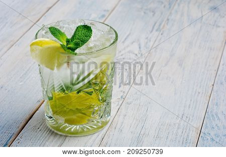 Alcohol mojito cocktil bar long drink fresh tropical beverage top view copy space highball glass, with rum, spearmint, lime juice, soda water and ice on white concrete table .